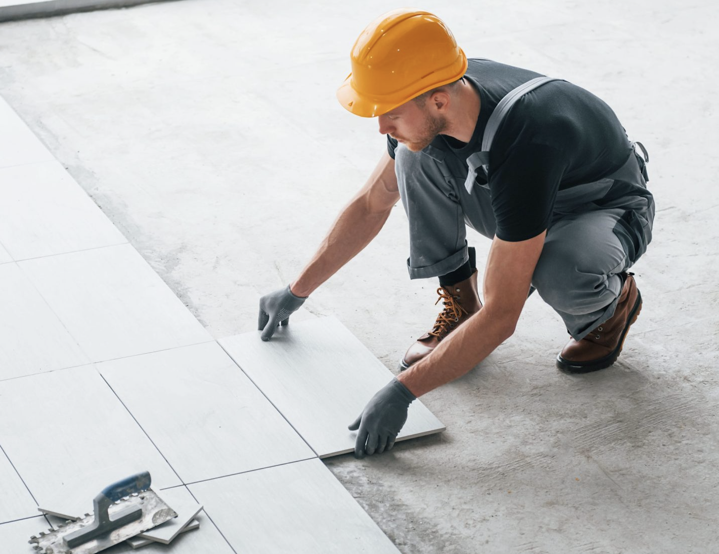 Carreleur posant du carrelage sur un chantier
